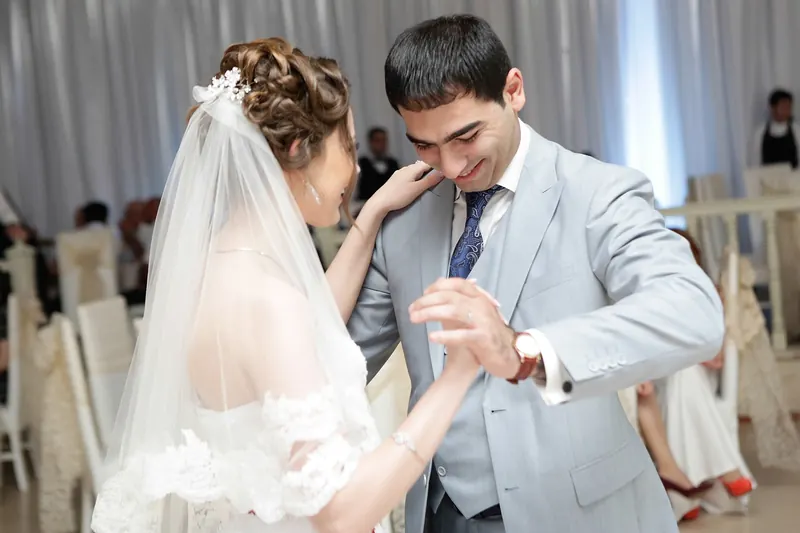 Mirii dansând, mireasa cu voal lung, într-o sală elegantă